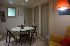 a dining room with a table and chairs and a lamp at Le Balcon in Dallet +12 photos
