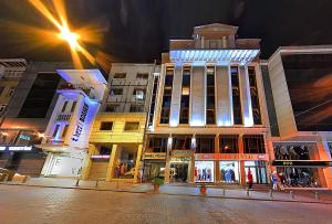 un grupo de edificios en una calle de la ciudad por la noche en Samir Deluxe Hotel, en Estambul