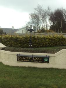 a sign for a university lodge in a park at Causeway Lodge in Bushmills