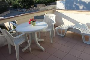 a white table and chairs sitting on a balcony at Small apartment Merica in Novalja