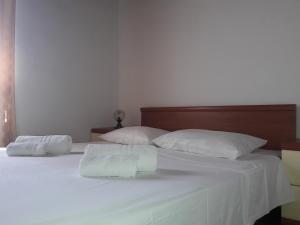 a white bed with two pillows and two towels at Small apartment Merica in Novalja