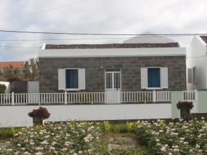 a house with a balcony and flowers at Casa Dos Mosteiros in Mosteiros