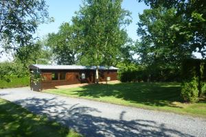 a small wooden cabin in the middle of a yard at Relais Du Saussay in Pertheville-Ners