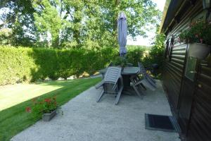 einen Tisch und Stühle mit Sonnenschirm auf einer Terrasse in der Unterkunft Relais Du Saussay in Pertheville-Ners