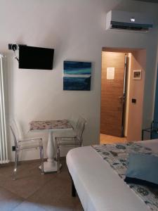 a bedroom with a table and chairs and a television on the wall at La Rosa Dei Venti in Monterosso al Mare