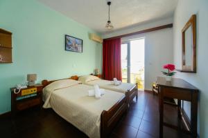 アルハンゲロスにあるTsambika Sun Hotelのベッド2台と窓が備わるホテルルームです。