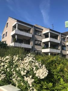 ein Apartmenthaus mit weißen Blumen davor in der Unterkunft Küstenbude Sonne in Grömitz