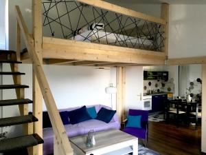 a loft bed in a living room with a purple couch at Apartment Olive Groove in Malinska