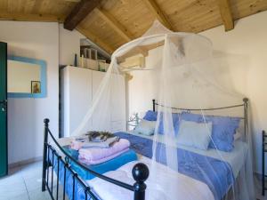 a bedroom with a canopy bed with blue pillows at Holiday Home near Adriatic Sea and Krka Falls in Šopot