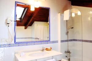 uma casa de banho com um lavatório e um espelho em San Clemente by Pousadas de Compostela em Santiago de Compostela