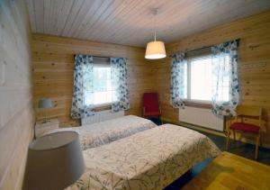 a bedroom with a bed and two windows at Kiiruna Kitkankieppi in Virrankylä