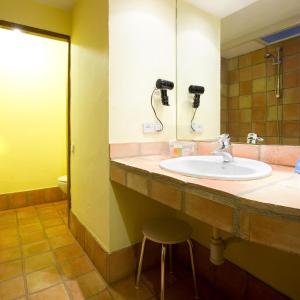 La salle de bains est pourvue d'un lavabo, d'un miroir et d'un tabouret. dans l'établissement Hotel la Perdiz, à La Carolina