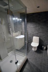 Un baño con ducha, inodoro y lavabo. en Kiiruna Kitkankieppi, en Virrankylä 17 fotos más