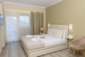 Кровать или кровати в номере Ammos Beach Seaside Luxury Suites Hotel