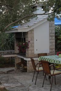a patio with a fireplace and a table and chairs at Small apartment Merica in Novalja