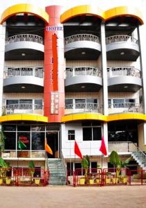 een groot gebouw met gele en rode balkons bij Hotel Arihant in Pachmarhī
