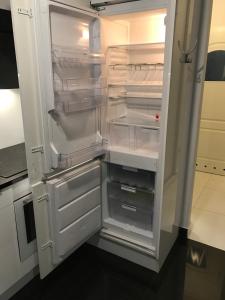 un frigorifero vuoto con la porta aperta in una cucina di Apartament "DESTINATION" przy AQUAPARKu a Reda