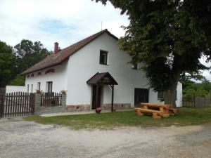 a white house with a picnic table in front of it at Penzion Starobor in Sedlice