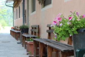 eine Reihe von Holzbänken neben einem Gebäude mit Blumen in der Unterkunft Agriturismo Ai Guiet in Superga