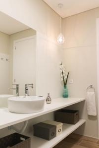 a white bathroom with a sink and a mirror at Garden House Ramalde in Porto +10 photos