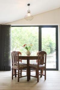 a dining room table with two chairs and a vase with flowers at Garden House Ramalde in Porto