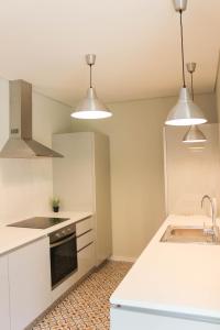 uma cozinha com balcões brancos e electrodomésticos brancos em Garden House Ramalde no Porto