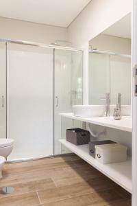uma casa de banho branca com um lavatório e um WC em Garden House Ramalde no Porto