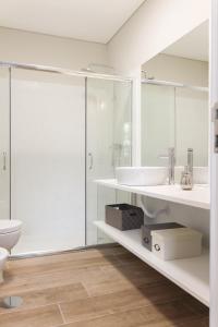 a white bathroom with a sink and a toilet at Garden House Ramalde in Porto