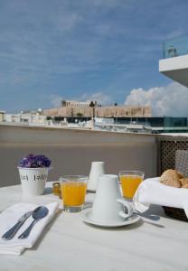 a table with a breakfast of coffee and orange juice at Hera Hotel in Athens