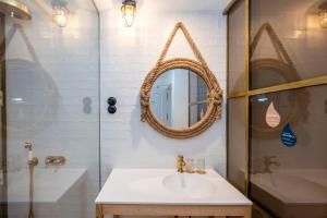 een badkamer met een wastafel en een spiegel bij Nao Catedral Boutique Hotel in Ciutadella