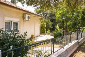 a fence in front of a house with a tree at Holiday home I.D.A. in Banjole
