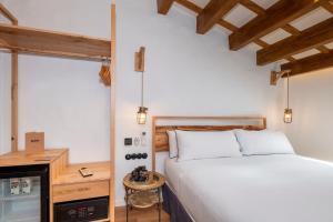 a bedroom with a bed and a desk and a window at Nao Catedral Boutique Hotel in Ciutadella