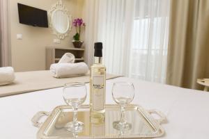 a bottle of wine sitting on a tray with two glasses at Ammos Beach Seaside Luxury Suites Hotel in Olympic Beach