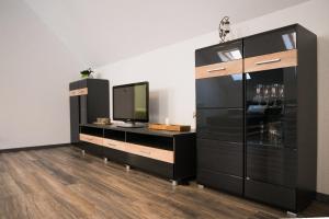 a living room with a tv and a black dresser at La Strada in Sebeş