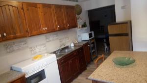 a kitchen with wooden cabinets and a white stove top oven at Vera Vacanza in Sannicola