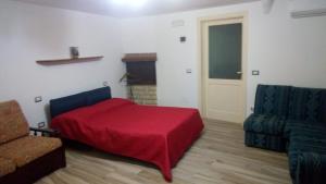 a bedroom with a red bed and a chair at Vera Vacanza in Sannicola +8 photos