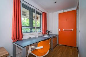 un bureau orange avec un bureau et une chaise dans l'établissement LSE High Holborn, à Londres