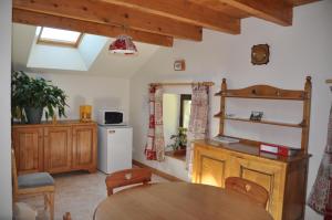 una cocina con armarios de madera y una mesa en una habitación en La Boissellerie, en Saulxures-sur-Moselotte