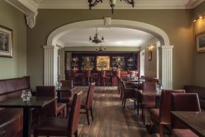 un restaurante con mesas y sillas y un bar en An Chúirt Hotel, Gweedore, Donegal en Gweedore