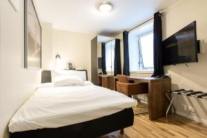 - une chambre avec un lit, un bureau et une télévision dans l'établissement Chesterfield Hotel, à Trondheim