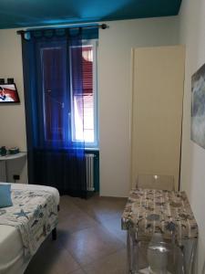 モンテロッソ・アル・マーレにあるラ ロサ デイ ヴェンティのベッド、テーブル、窓が備わる客室です。