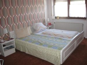 a bedroom with a bed with a large headboard at Pension Haus Ursula in Koblenz