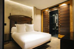 a bedroom with a white bed and a shower at Hotel Bagués, a Small Luxury Hotel of the World in Barcelona
