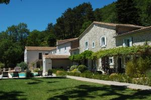 a large stone house with a yard and a pool at Les Jardins de Soulane B&B - Adults only in Belcastel-et-Buc