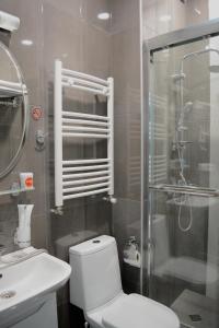 a bathroom with a toilet and a shower and a sink at Hotel Nicolas in Tbilisi City