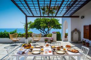 - une table blanche avec de la nourriture sur la terrasse dans l'établissement Helidoni Hill seaview family villa, à Palaiokastro