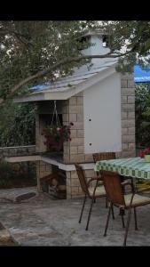 a table and chairs in front of a stone fireplace at Apartments Merica in Novalja