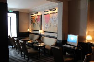 a waiting room with a table and chairs and a computer at Hotel Saint Cyr Etoile in Paris