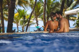um homem e uma mulher sentados numa prancha de surf numa piscina em Catalonia Royal Tulum Beach & Spa Resort Adults Only - All Inclusive em Xpu Há