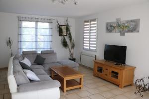 uma sala de estar com um sofá e uma televisão de ecrã plano em Charmante maison de village em Cucuron